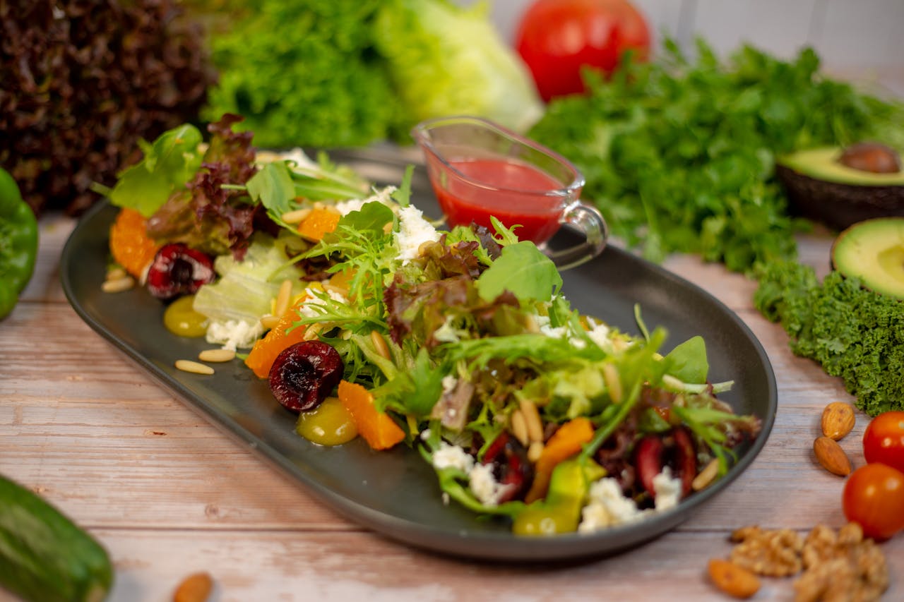 A vibrant salad with mixed greens, nuts, and fruits, set on a stylish black plate, ideal for a healthy meal.