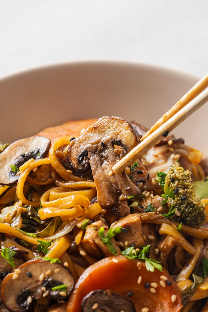 Savor this vibrant stir-fry with mushrooms, broccoli, and noodles, perfectly garnished for a culinary delight.